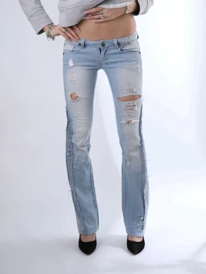 Ljusblå slitna bootcut jeans - Jättefina och unika lågmidjade jeans med slitningar och säkerhetsnålar som extra detaljer. Jeansen är bootcut och har fina detaljer.   - Storlek: XS-S - Midjemått: 38 cm - Innerbenslängd: 83 cm - Modellen är 175 cm lång för referens  Jeansen är i jättebra skick och har inga defekter (vad vi märkt)!!  Vid frågor eller funderingar - tveka inte att höra av dig🪽 