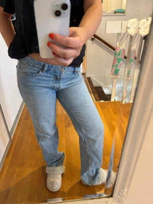 Ljusblå raka jeans från Levi's - Säljer ett par ljusblå jeans från Gina tricot med klassisk femficksmodell och raka ben. Jeansen har låg midja och är tillverkade i ett mjukt denimtyg. Perfekta för en avslappnad och trendig look.