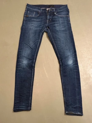 Tiger of sweden jeans  - Snygga mörkblå slim fit jeans med slitningar och tvättade detaljer. Klassisk femficksmodell med dragkedja och knapp i midjan. Jeansen har kontrastsömmar och är tillverkade i denim med lite stretch för skön passform.pris kan diskuteras. 