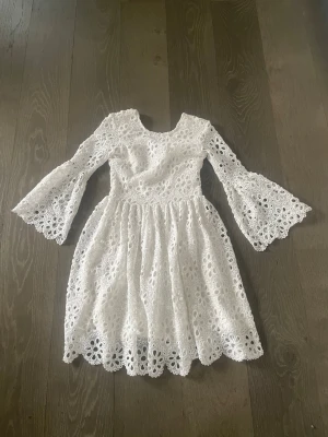 Studentklänning❤️ - Superfin vit kortklänning i spets med blommigt broderat mönster. Klänningen har v-ringning i ryggen, trekvarts trumpetärmar och volangkant nedtill. Perfekt för sommarens alla tillfällen och ger en romantisk vibe. Perfekt till studenten❤️ Kolla gärna mina andra studentklänningar på min profil🫶