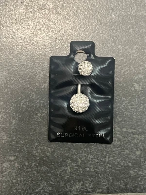 Glittrande navelpiercing i stål - Aldrig använd. 