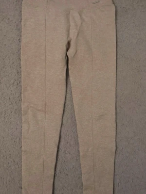 Beige leggings från Aimn - Säljer ett par snygga beige leggings från Aimb. Materialet är stretchigt och har en diskret struktur som ger en cool look. Perfekta för dig som vill ha både stil och komfort.