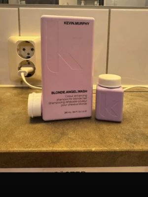 Kevin Murphy Blonde Angel Wash schampo - Ljuslila schampo från Kevin Murphy, Blonde Angel Wash, speciellt framtaget för blont hår. Kommer i en rektangulär plastflaska med skruvlock och en mindre matchande burk. Perfekt för att fräscha upp och förstärka blonda nyanser.                        Den lilla flaskan får du på köpet.