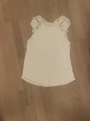 Vit spetsdetaljerad linnetopp H&M - Säljer en söt vit linnetopp från H&M i storlek XS. Toppen har fina spetsdetaljer vid axlarna och är ärmlös med rund halsringning. Perfekt för en fräsch och somrig look. Materialet känns mjukt och luftigt. Har tyvärr ett hål vid halsen (kolla bild) o några små fläckor båda fram o bak men skulle inte säga att dem syns så mycket! Har ej provat att tvätta den än så fläckarna kan gå bort!❣️❣️