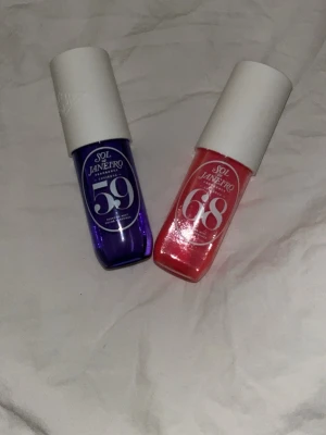 Sol de Janeiro parfymmist duo - Två Sol de Janeiro parfymmister: Cheirosa 59 i lila flaska och Cheirosa 68 i rosa flaska. Båda har vita lock och modern, rundad design. Perfekt för dig som gillar fräscha och unika dofter i snygga flaskor. den rosa har även glitter i sig vilket gjort att de går sämre att spruta, men den blåa är helt normal. de båda är äkta sol de janeiro