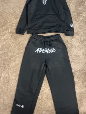 Saint Brazilian tracksuit  - Säljer ett par svarta mjukisbyxor från Saint med vit logga och text framtill samt vid benet. Byxorna har resår i midjan och raka ben. Perfekta för chill dagar och streetwear-stil.