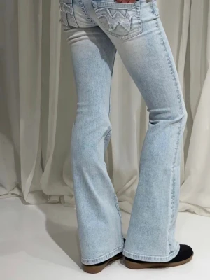 Low waist bootcut - Säljer ett par ljusblå bootcut jeans från  med ikoniska sömmar och broderade bakfickor. Jeansen har låg midja. Avklippta längst ner då de var för långa. Passar någon mellan 155-157