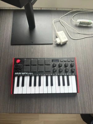 AKAI MPK mini MIDI-kontroller 🎹 Som ny - Säljer en AKAI MPK mini MIDI-kontroller med svart och röd design. Den har 25 tangenter, åtta pads, åtta rattar och en joystick för pitch/modulation. Perfekt för musikproduktion och beatmaking. Kompakt format som passar både studio och hem. HELT OANVÄND
