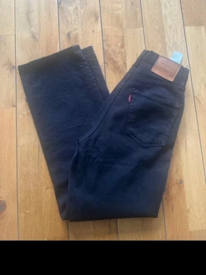 Svarta Levi's raka jeans ribcage 23/27 - Säljer ett par svarta jeans från Levi's med klassisk hög i midjan 