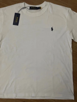 Vit t-shirt från Polo Ralph Lauren - Klassisk vit t-shirt från Polo Ralph Lauren med rund hals och korta ärmar.  Storlek S-M ganska bred i storleken. Kontakta mig för fler frågor 