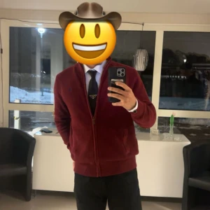 Vinröd stickad ziptröja Polo Ralph Lauren - Säljer en vinröd stickad ziptröja från Polo Ralph Lauren med hög krage och dragkedja framtill. Tröjan har en diskret blå logga broderad på bröstet och är perfekt för lager-på-lager-stil. Klassisk och stilren design.