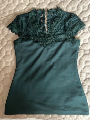 Grön festtopp med spets - Har ingen lapp och vet inte vilket märke. Jag har aldrig använt den. 