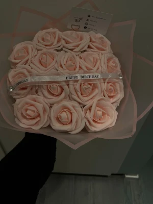 Bukett med ljusrosa konstrosor - Säljer en fin bukett med ljusrosa konstgjorda rosor inslagna i transparent rosa cellofan och dekorerad med ett vitt band där det står 'Happy Birthday'. Perfekt som födelsedagspresent eller bara en vanlig present till den du älskar💞🤗 