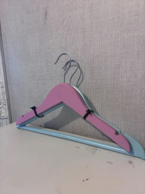 Set om 2 vackra galgar i rosa och ljusblå - Set om 2 vackra galgar i puderrosa och ljusblå. Hög kvalitet med starka metallkrokar. Perfekta för barnkläder eller fina plagg!