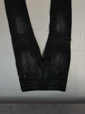 Svarta ripped jeans Supply & Demand. Pris kan diskuteras - Snygga svarta jeans från Supply & Demand med slitna detaljer och hål på knäna. Jeansen har en smal passform och coola slitningar samt färgstänk för en trendig look. Perfekta för dig som gillar streetstyle och vill sticka ut.