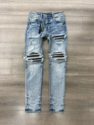 Ljusblå slitna skinny jeans - Säljer ett par ljusblå skinny jeans med slitningar och hål över knäna. Jeansen har en tvättad look, dragkedja och knapp i midjan samt klassiska fem fickor. Snygga detaljer med trasiga partier och råa kanter. Perfekta för en trendig streetstyle.
