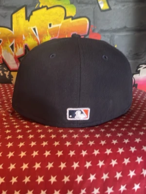Houston Astros svart keps New Era - Svart keps från New Era med Houston Astros logga broderad framtill i vitt och orange. Klassisk 59FIFTY-modell med platt skärm och MLB-logga baktill. Perfekt för dig som gillar streetstyle och sportiga accessoarer.