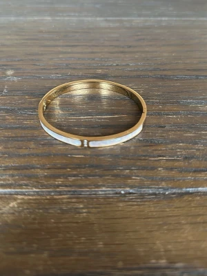 Guldigt armband med pärldetaljer - 18K guldpläterad. I härdat stål. Sjukt elegant som lyfter outfiten. 