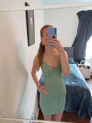 Ljusgrön ribbad kort klänning - Snygg ljusgrön kort klänning med ribbad struktur och spetsdetaljer vid urringningen. Klänningen har tuna axelband och har en figurnära passform som framhäver siluetten. Perfekt för sommaren storlek xs/s, skriv om ni har frågor, priset går att diskutera 