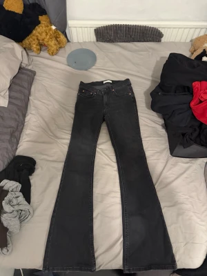 Svarta bootcut jeans från Gina tricot  - Säljer ett par svarta bootcut jeans från Gina Jeans. De har klassisk femficksdesign, hög midja och utsvängda ben. Materialet är mjukt och stretchigt denim som sitter snyggt och bekvämt. Perfekt för dig som gillar en cool och tidlös look.