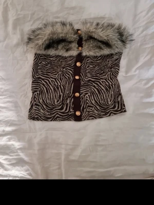 Coop topp - Riktigt cool och unik tub topp med päls och detaljerade guldknappar som jag tycker ger bratz vibes. Storlek M och i väldigt fint skick. Katt finns i hemmet. Jag har fler klädannonser uppe 