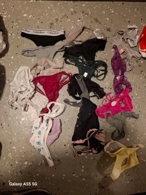 Stort set med underkläder i olika färger 32 st - Säljer ett stort set med underkläder, inklusive flera bodys, trosor och bh:ar i olika färger som svart, rosa, lila, beige, vitt och grönt. Materialen varierar mellan spets, bomull och syntet. Några plagg är från Calvin Klein och andra är spetsiga och färgglada.