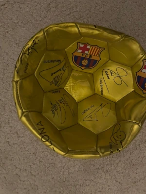 Signerad Barca fotboll - Jag säljer en ny Barcelona boll i färgen guld. Den är helt ny och funkar perfekt för antingen dekoration eller så kan man spela med den, kontakta om pris.