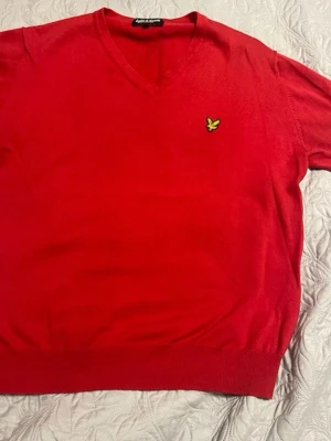 Röd tröja från Lyle & Scott - Röd stickad tröja med V-ringning från Lyle & Scott. 