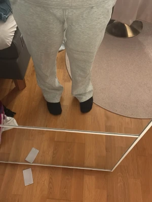 Ljusgrå mjukisbyxor med dragsko - Säljer ett par ljusgrå mjukisbyxor med rak passform och resår i midjan samt dragsko för justerbar komfort. Tillverkade i mjukt sweatshirtmaterial som är perfekt för chill dagar. Klassisk design utan synligt märke. Pris kan alltid diskuteras