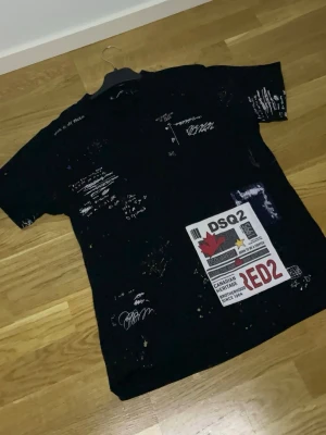 Svart dsquared2 tröja till salu. - Snygg och trendig svart tröja med unika grafiska detaljer och färgstänk som ger en modern och edgy look. Perfekt för dig som vill sticka ut och samtidigt hålla en stilren bas i din outfit. Tröjan har ett coolt tryck framtill och passar lika bra till jeans som till mer uppklädda streetwear-stilar.    Storlek: S Skick: Bra skick    En riktigt stilren piece som lyfter vilken outfit som helst! ✨  