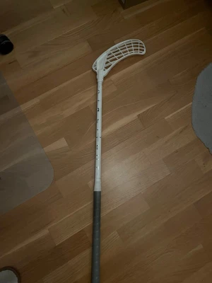 Zone airlight 29 - Säljer nu en Zone airlight innebandyklubba. Klubban är vit med silvriga detaljer. Det är ett vitt Hyper blad i PP plast monterat på klubban. Den är 92cm lång och har 29 flex. Den har slagmärken på skaftet (se sista bilden), i övrigt är den i fint skick. Vid frågor eller funderingar är det bara att höra av sig. Pris kan diskuteras.