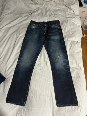 Levis 501 jeans - Säljer ett par mörkblå jeans med raka ben och snygga slitningar. 