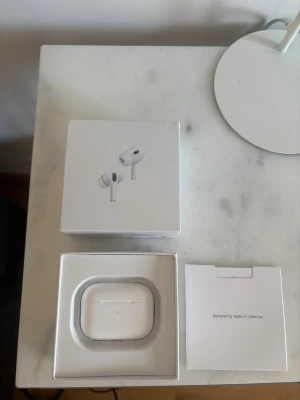 Apple AirPods Pro 2 - Säljer ett par vita Apple AirPods Pro med trådlöst laddningsetui. Snygg och kompakt design i plast, perfekt för dig som vill ha brusreducering och grymt ljud till mobilen. Levereras i originalförpackning med tillbehör.