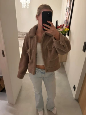 Beige teddyjacka med stora fickor - Säljer en beige teddyjacka med oversized passform och stora bröstfickor. Jackan har bred krage och stängs med knappar framtill🫶🏻