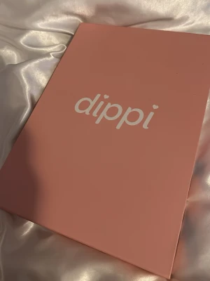 Dippi sminkborste och tillbehörsset - Säljer ett komplett sminkverktygsset från Dippi i en snygg rosa förpackning. Setet innehåller en kompakt borste, två nagelfiler, fyra burkar för att sätta ditt pulvret (nagelfärgen) och två burkar med pulver som är själva nagellacket. Har använt detta två gånger så brukarna med pulver är fulla. Färgerna på nagellacken är vitt och babyrosa. Originalpris var 799.