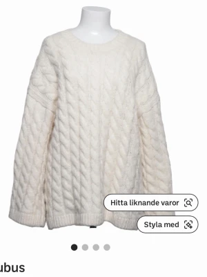 Vit kabelstickad tröja från Cubus - Mysig vit kabelstickad tröja från Cubus med rund halsringning och avslappnad passform. Tröjan har långa ärmar och ribbade muddar vid ärmslut och nederkant. Perfekt för lager på lager och en clean look.