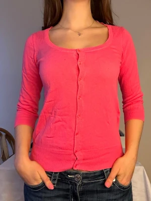 Rosa kofta med trekvartsärm🩷 - Snygg rosa kofta med rund halsringning och trekvartsärm. Koftan har knäppning framtill med små knappar och ribbade muddar vid ärmslut och nederkant. Perfekt att slänga över en topp för en färgklick i vardagen.🩷