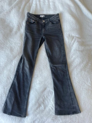 Grå bootcut jeans med utsvängda ben - Snygga grå bootcut jeans med utsvängda ben och klassisk femficksmodell. Jeansen har normal passform.