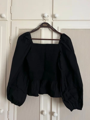 Svart blus med puffärmar - Säljer denna fina blus då den inte kommer till användning! I fint skick då den är använd fåtal gånger, med söta puffiga ärmar och ett stretchigt material!