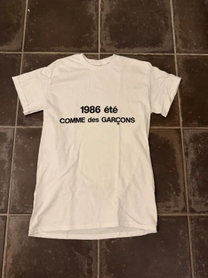 Commes des garcons t shirt - Riktigt fet och eftertraktad t-shirt med commes des garcons loggan i storlek S. Väldigt bra skick!  Obs: Jag är lite osäker på äktheten då lappen i nacken saknas, därför säljs den billigare (499 kr, nypris ca 3000 kr).  längd cirka 65cm, bredd cirka 44cm. Tveka inte att höra av dig vid frågor eller funderingar!