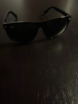 Svarta Wayfarer solglasögon - Snygga svarta solglasögon i klassisk wayfarer-modell med mörka glas. Ramen är i blank plast och bågarna har en stilren design som passar till de flesta outfits. Perfekta för dig som vill ha en tidlös accessoar till sommarn! En liten skada på glaset från insidan uppe i hörnet som man ser på bilden men det är inget som syns både från utsidan och insidan. Kom dm för frågor!