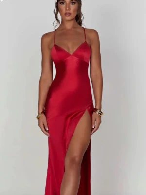Röd långklänning med slits och öppen rygg - Snygg röd balklänning  i satin med smala axelband, v-ringning och slits framtill. Klänningen har öppen rygg med snörning som gör det möjligt att justera passform. Endast använd en gång och i mycket bra skick, bortsett från lite nopprar (exempelvis sista bilden). Klänningen köptes från Babyboo.