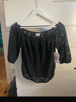 Svart off shoulder spetstopp Nelly - Säljer en svart off shoulder topp från Nelly. Det är en spettstopp o den är helt ny köpt men den är för liten för mig o kan inte retunera tröjan. Jätte fin och prislappen sitter kvar den är helt oanvänd.