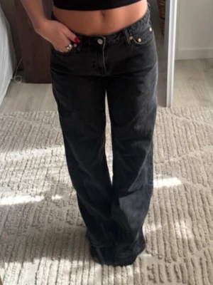 lågmidjade jeans från gina - Säljer ett par svarta raka jeans från Gina med låg midja. Jeansen har en avslappnad passform och är tillverkade i kraftig denim. Jag brukar vanligtvis ha storlek 36 men köpte storlek 40 för en mer overzised fit. 