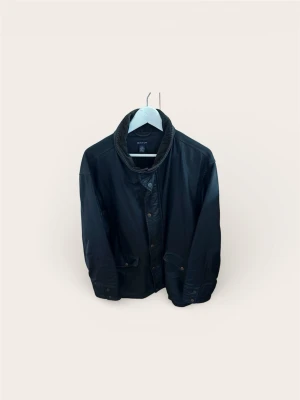 Sällsynt Skinnkappa från Gant (M) - Säljer en exklusiv och rejäl skinnjacka från GANT. Detta är en utgången premium-modell som inte längre går att köpa i butik. Klassisk "Car Coat"-design med knäppning framtill, krage och rejäla fickor. Tidlös stil som fungerar lika bra över kostymen som till jeans och stickat.  Svart läder av hög kvalitet som har mjuknat snyggt.  Skick: Fint begagnat skick! Jackan är använd och har fått en naturlig patina (som skinn ska ha), men är hel och välvårdad.  Storlek: Medium (M). 