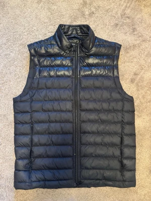 J.Lindeberg Väst - Säljer denna svarta väst från J.Lindeberg. Nypris 1600. Nästan helt använd och har därför inga hål eller fläckar. Storlek M. Passar in i vardagen och i sportsliga sammanhang.  Hör gärna av dig vid frågor eller prisförslag.