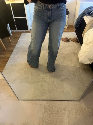 Blåa  jeans från Bershka - Säljer ett par blåa wide leg jeans från Bershka med mellan hög midja, storlek 36