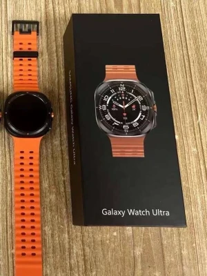 Galaxy Watch Ultra med orange armband - Snygg Galaxy Watch Ultra med fyrkantig svart urtavla och ett sportigt orange silikonarmband. Klockan har en modern design med tydliga knappar på sidan och passar perfekt för dig som gillar teknik och smarta funktioner på handleden.