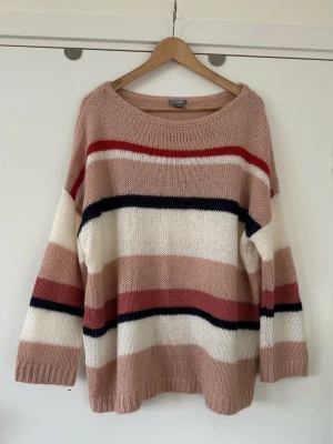 Lindex - stickad rosa vit tröja - storlek M - Mysig stickad tröja från Lindex i storlek M med breda ränder i puderrosa, vitt, svart och rött. Tröjan har rund halsringning, långa ärmar och avslappnad passform. Perfekt för lager på lager och chill dagar. 15% mohair, gör materialet otroligt mjukt och lent. Mycket gott skick, som ny!