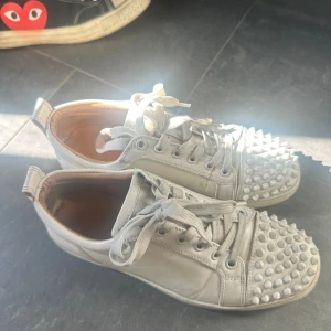 Vita Louboutin sneakers  - Unika vita sneakers från Christian Louboutin med vita nitar över tån och klassiska röda sulor. Använda men fortfarande bra i skick. Kan rengöras innan dom skickas✨ Pris kan diskuteras 